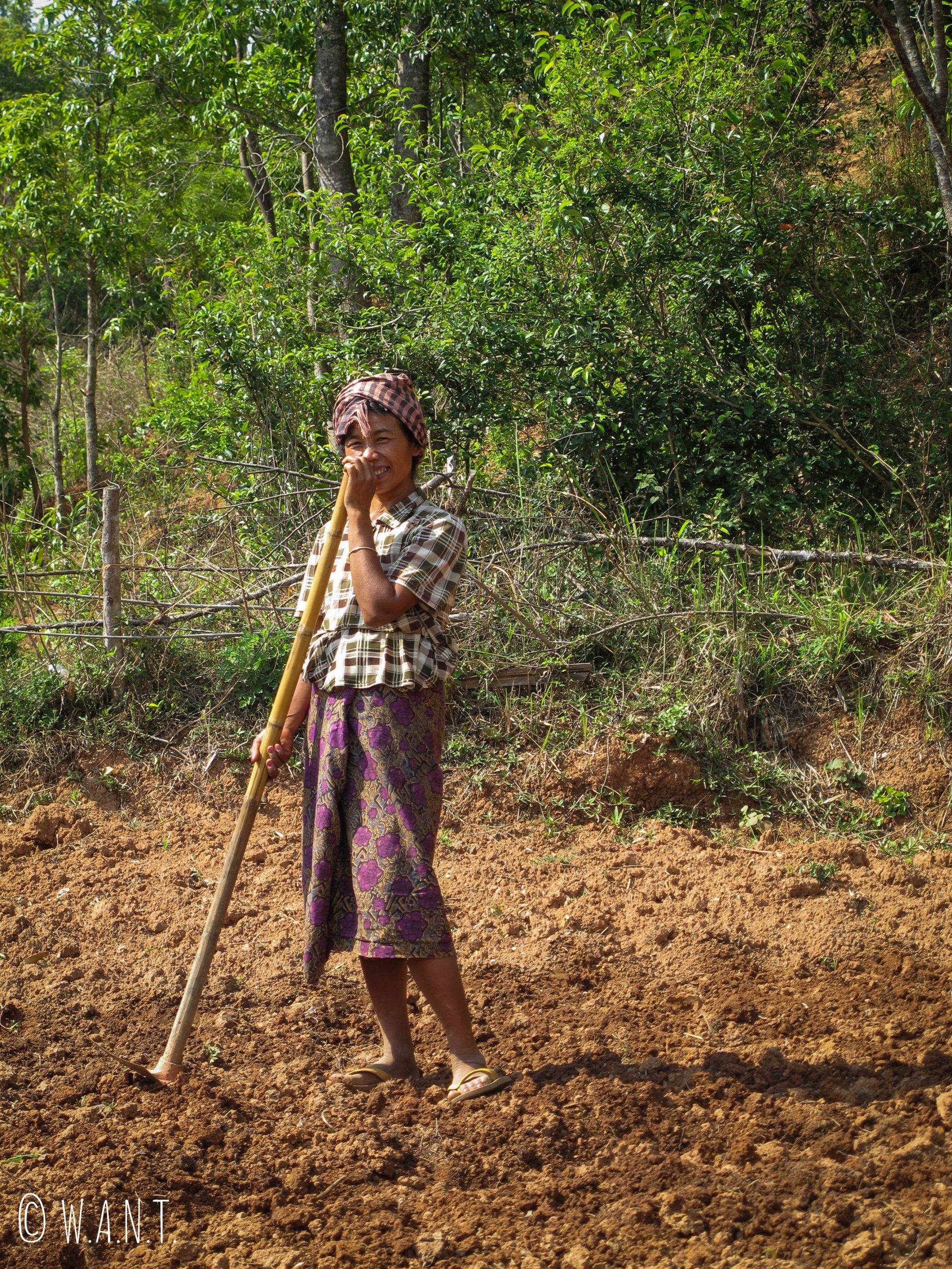 Jeune femme souriante malgré le travail difficile dans les champs