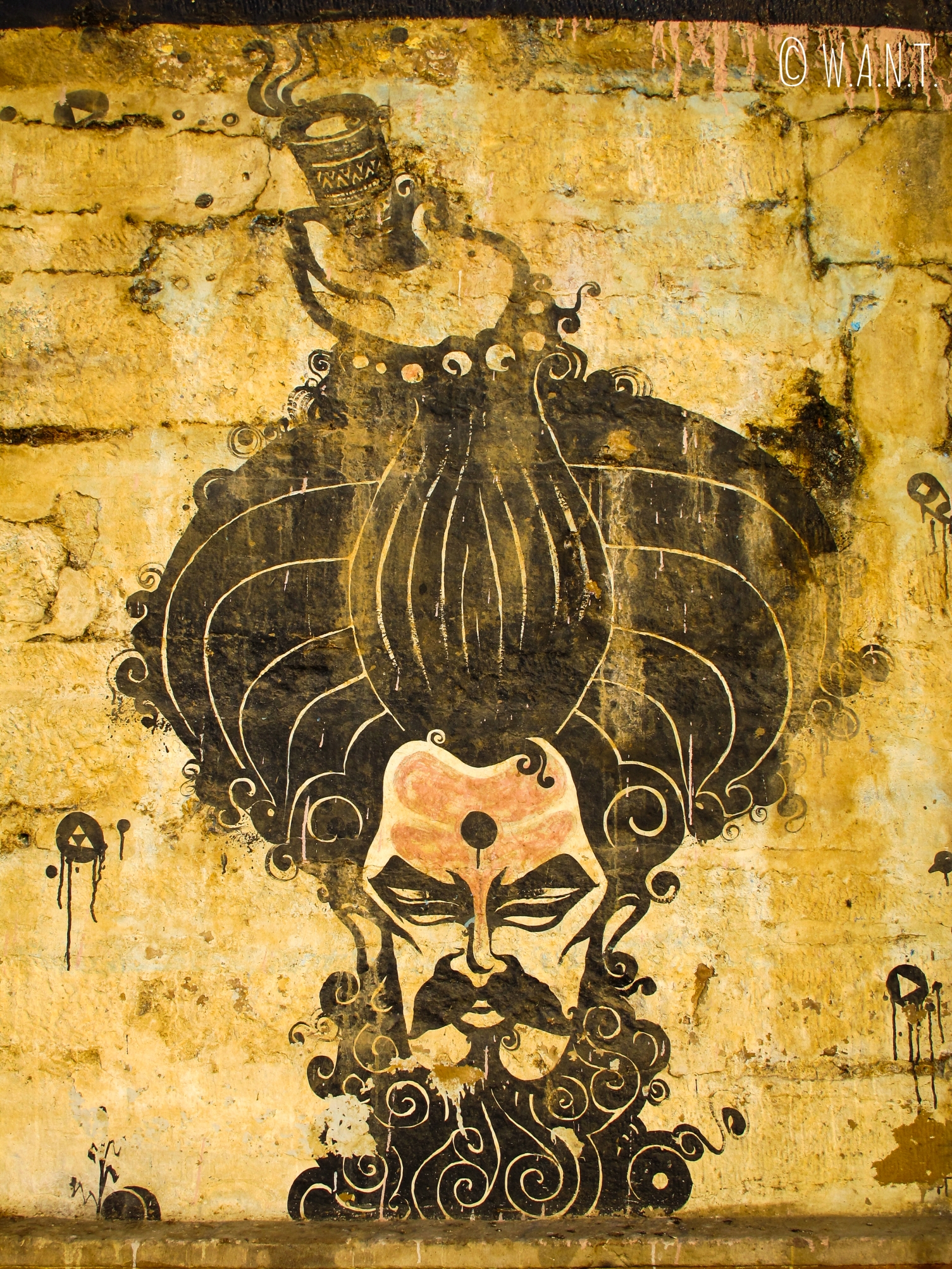 Art de rue - tête de Sadhu sur le mur d'un Ghat
