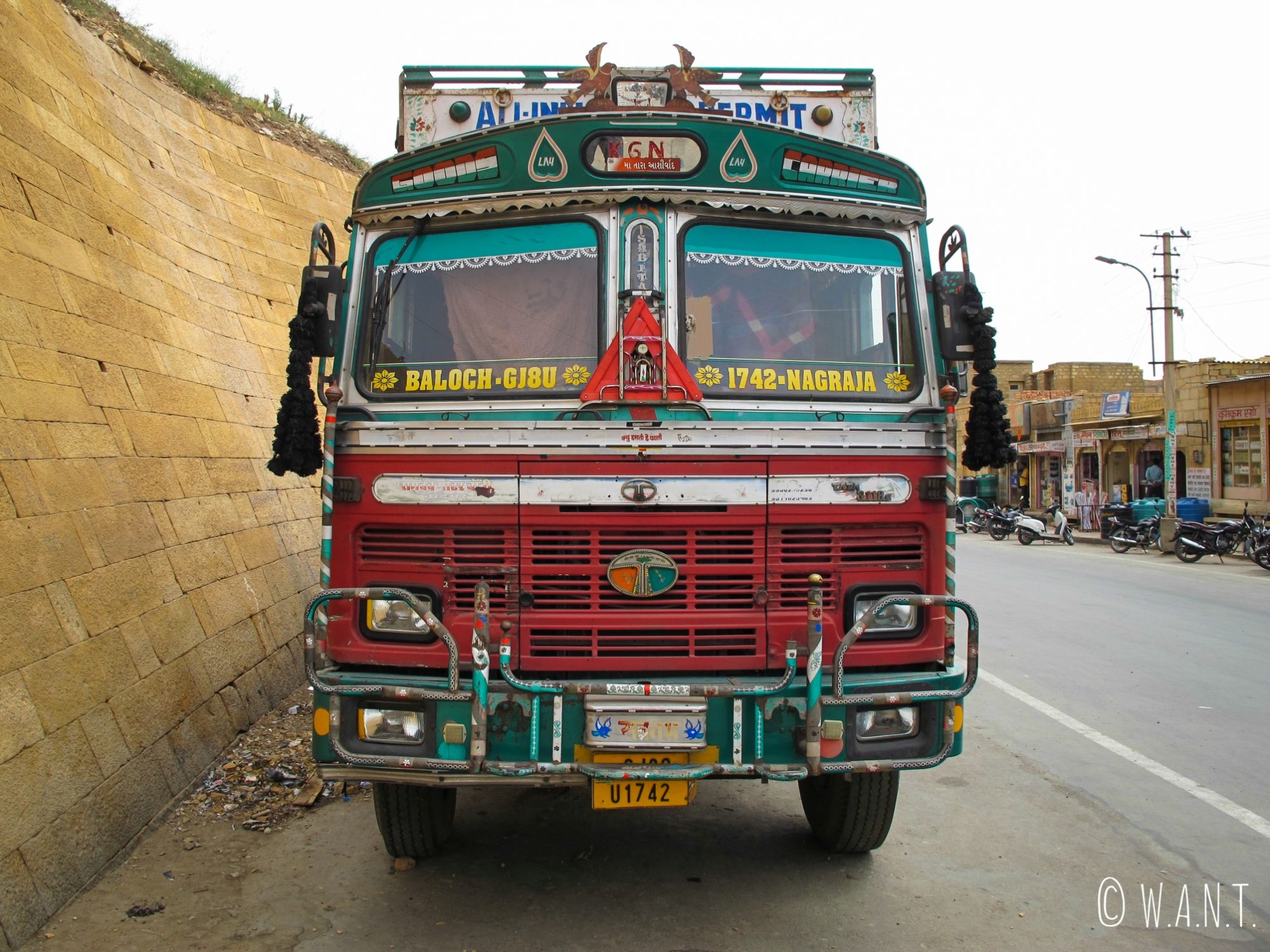 Face avant d'un camion benne Tata, aux multiples couleurs et ornements sacrés