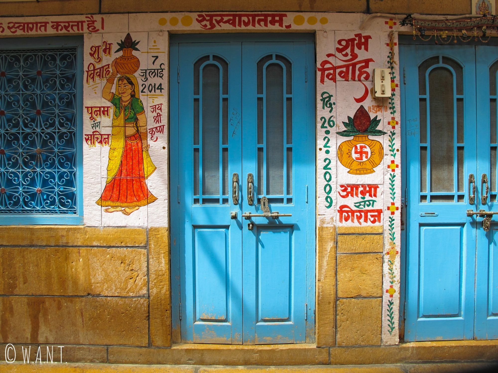 Peinture représentant une femme porteuse d'eau à l'entrée d'une maison dans les rues de Jaisalmer