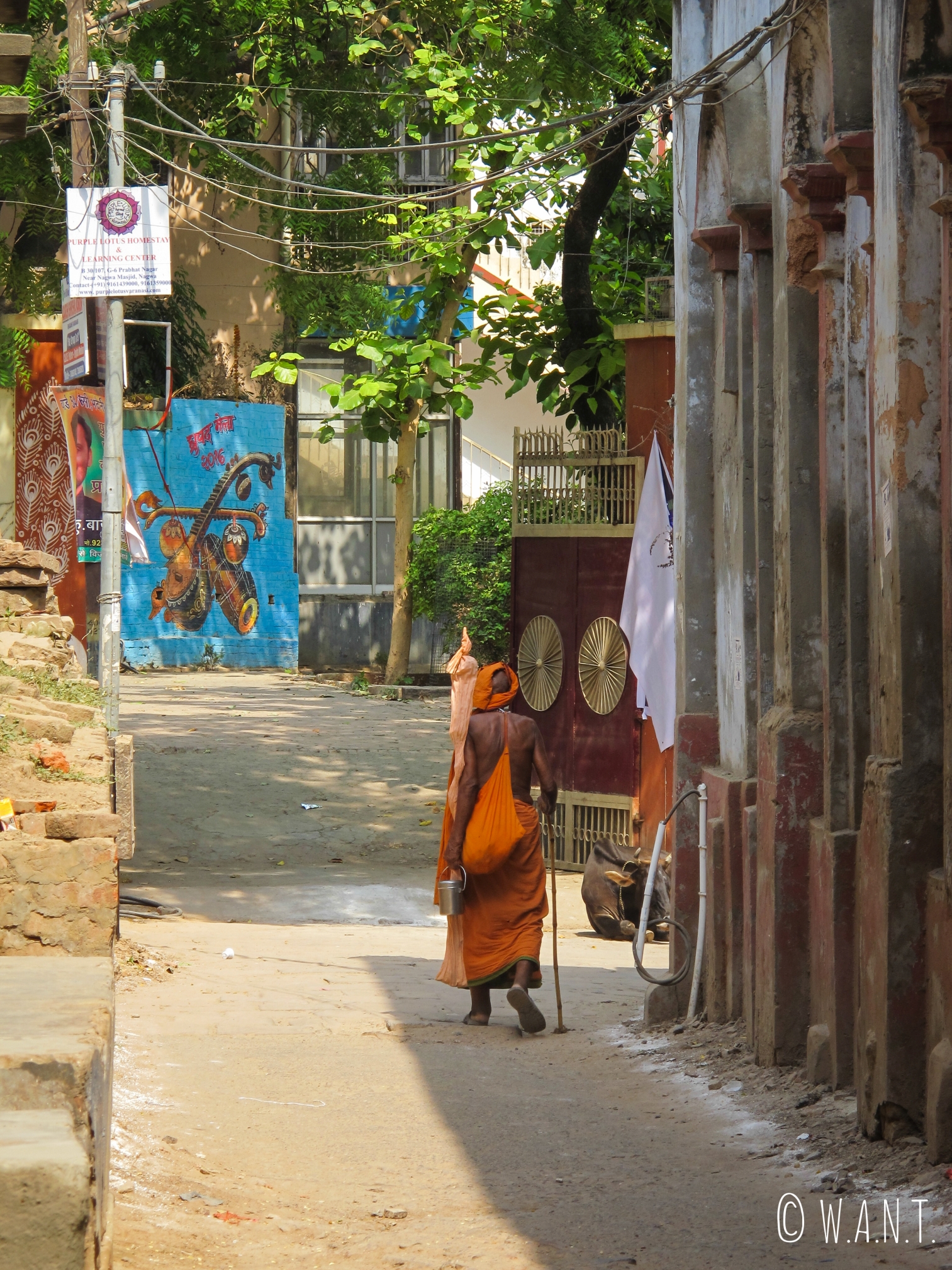 Sadhu, saint homme toujours vêtu de orange, marchant à l'ombre dans la rue