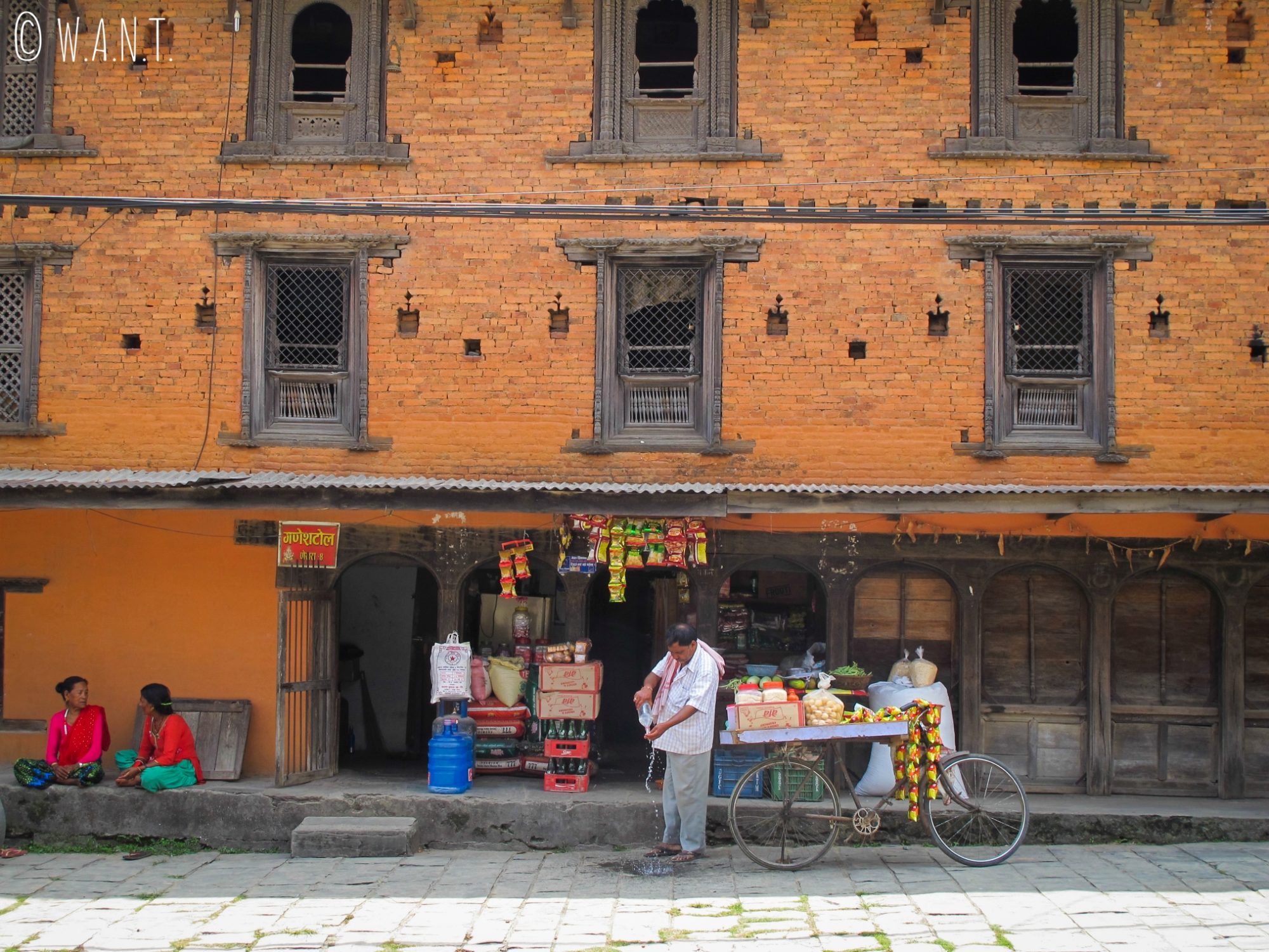Façade d'une bâtisse dans le vieux Pokhara et marchand ambulant