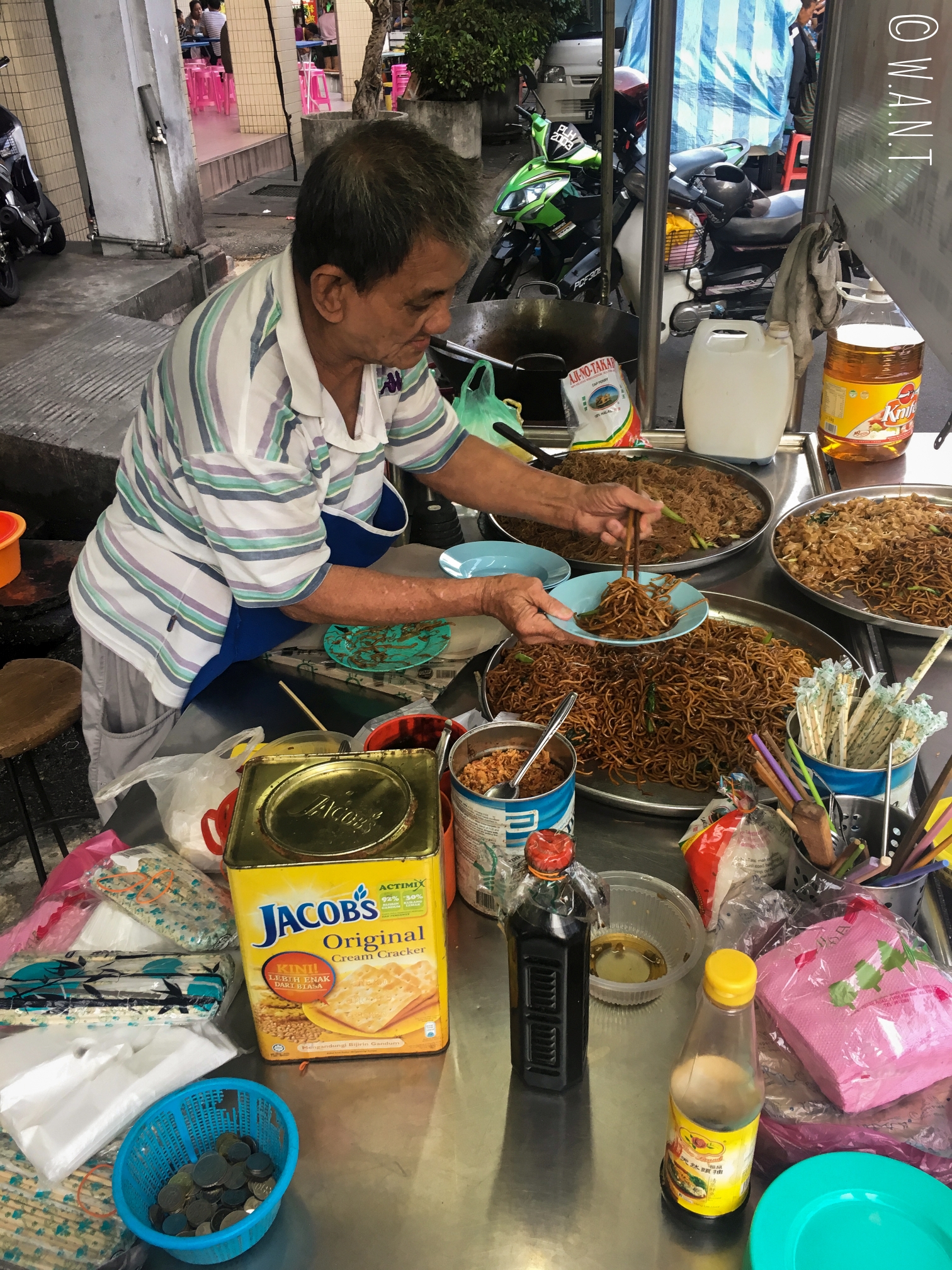 Ce vieil homme cuisine de délicieuses nouilles sur son stand installé rue Kimberley street à Penang