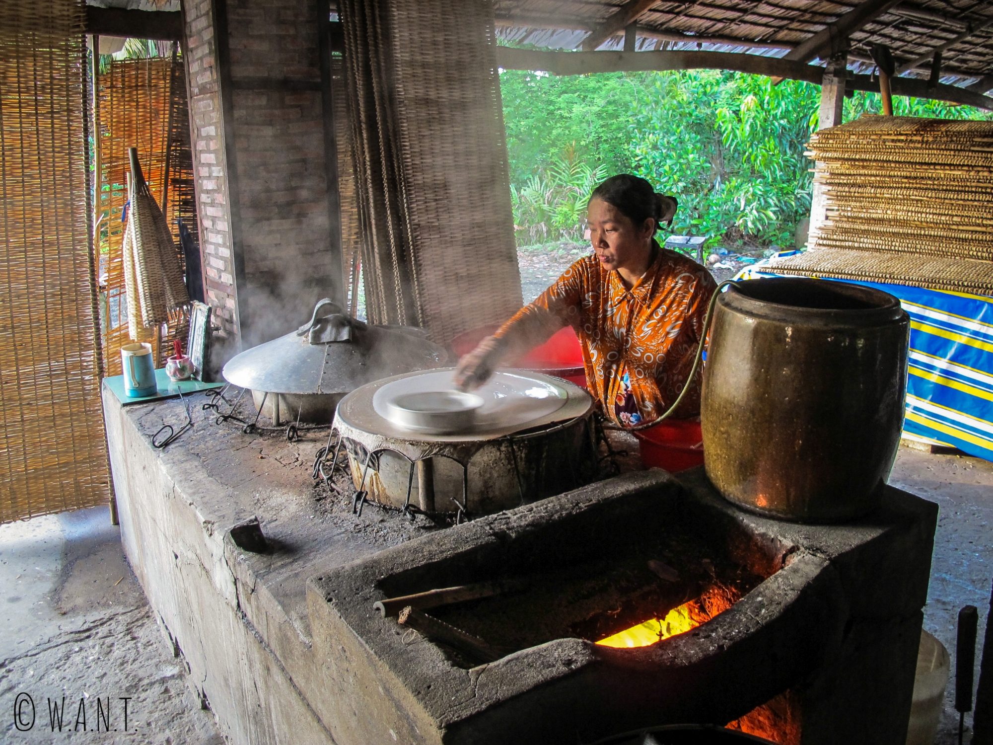 La pâte est étalée comme une crêpe pour réaliser une galette de riz dans le delta du Mékong