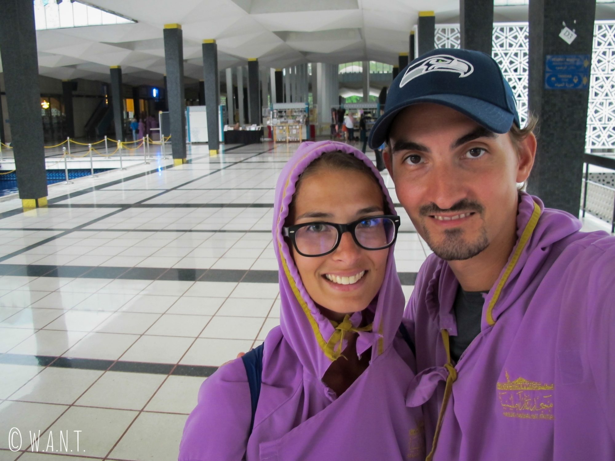 Pour visiter National Mosque, les hommes et les femmes doivent revêtir des robes longues violettes