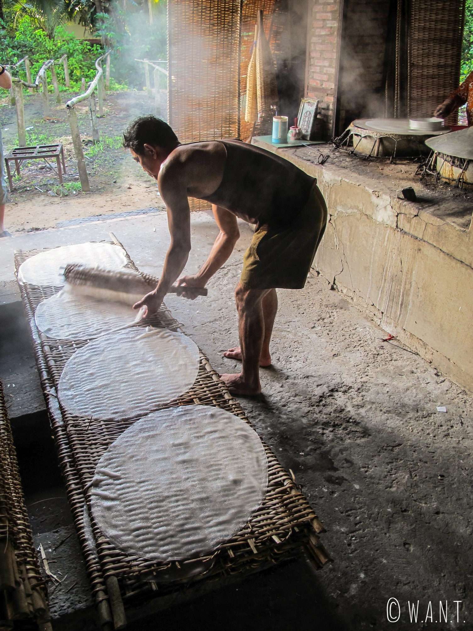 Une fois cuites, les galettes de riz sont déposées délicatement sur des plaques de bamboo