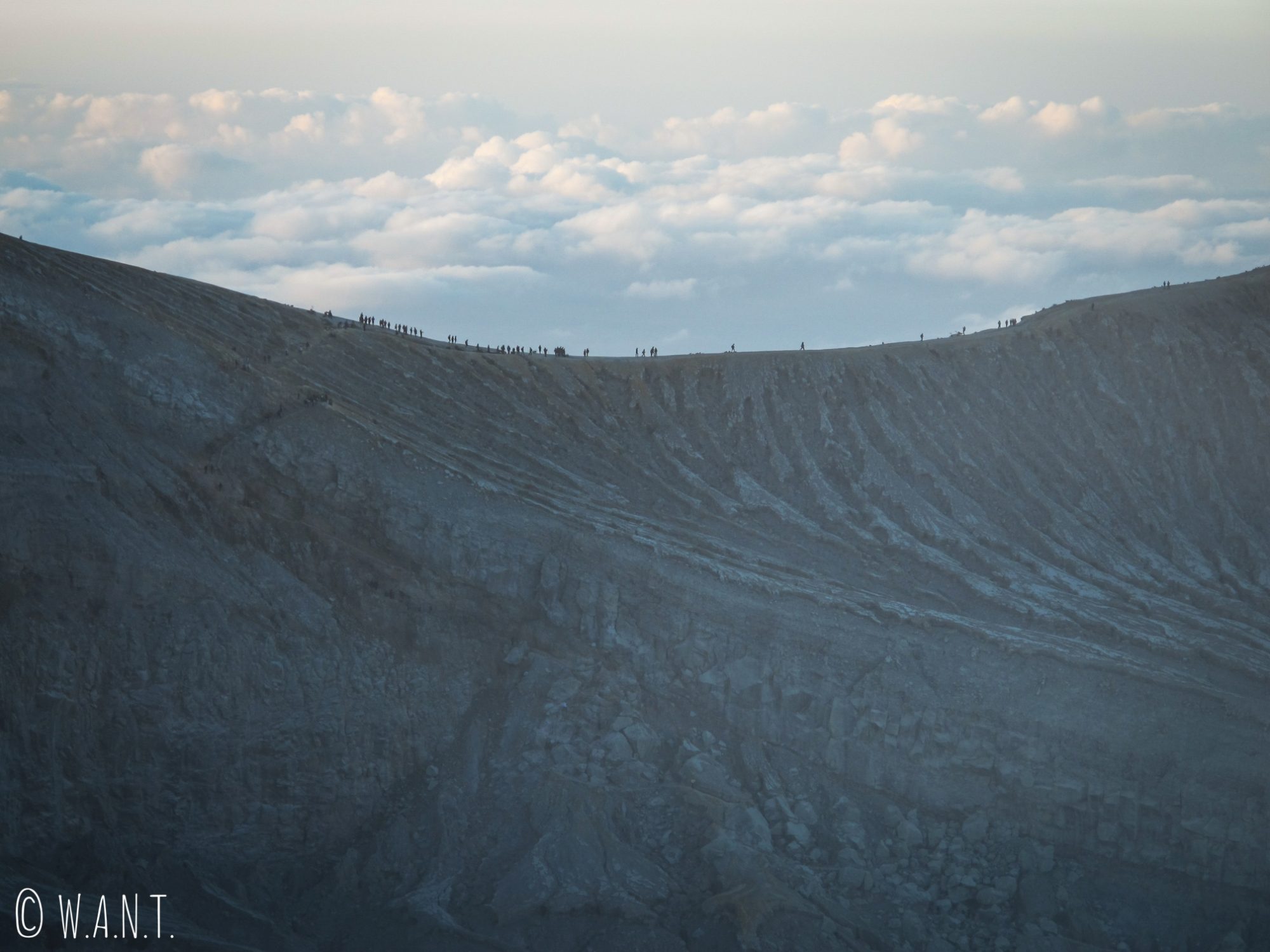 Foule qui se presse le long du cratère du Kawah Ijen au lever du soleil