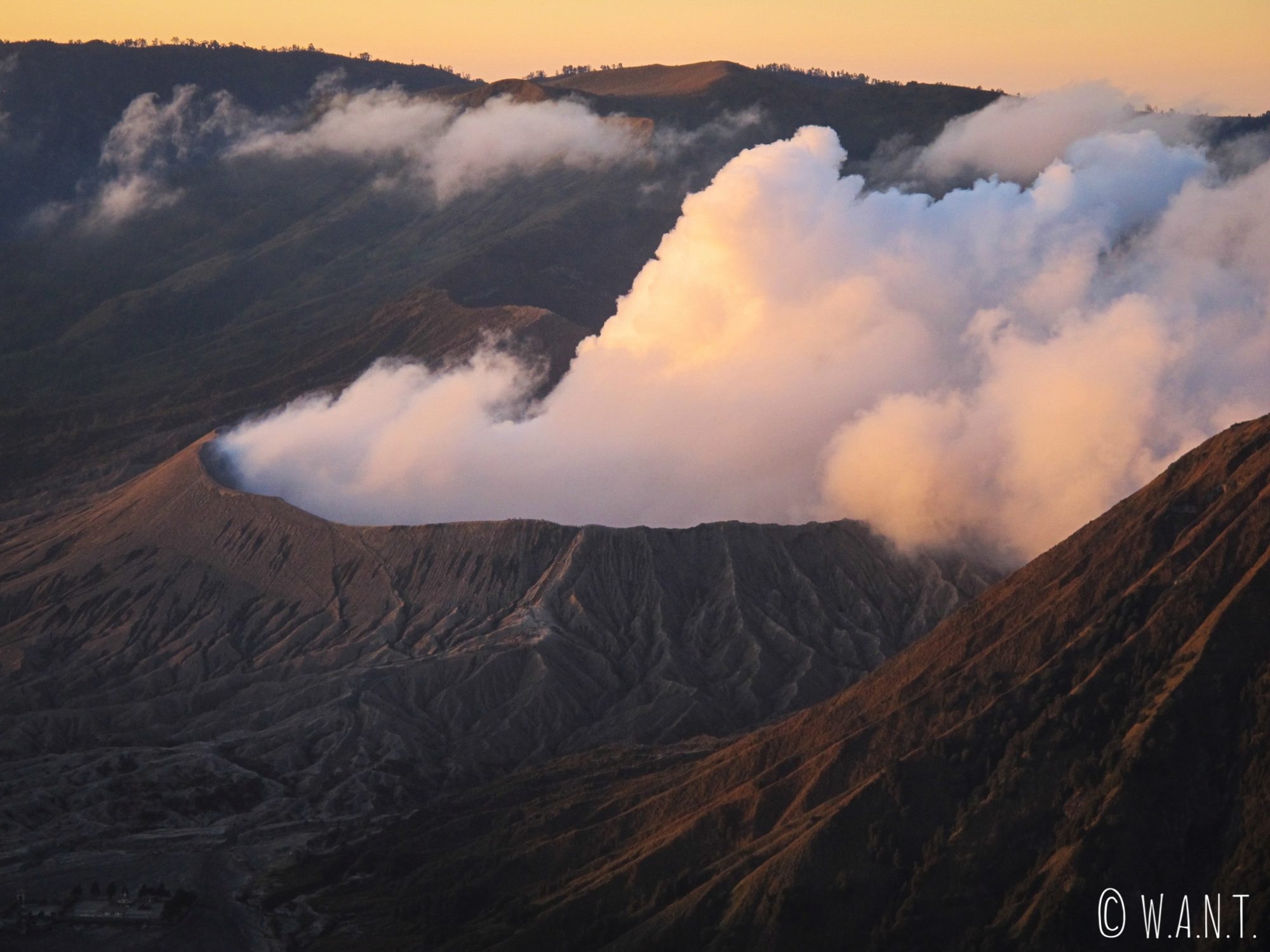 Gros plan sur le cratère fumant du Bromo au lever de soleil