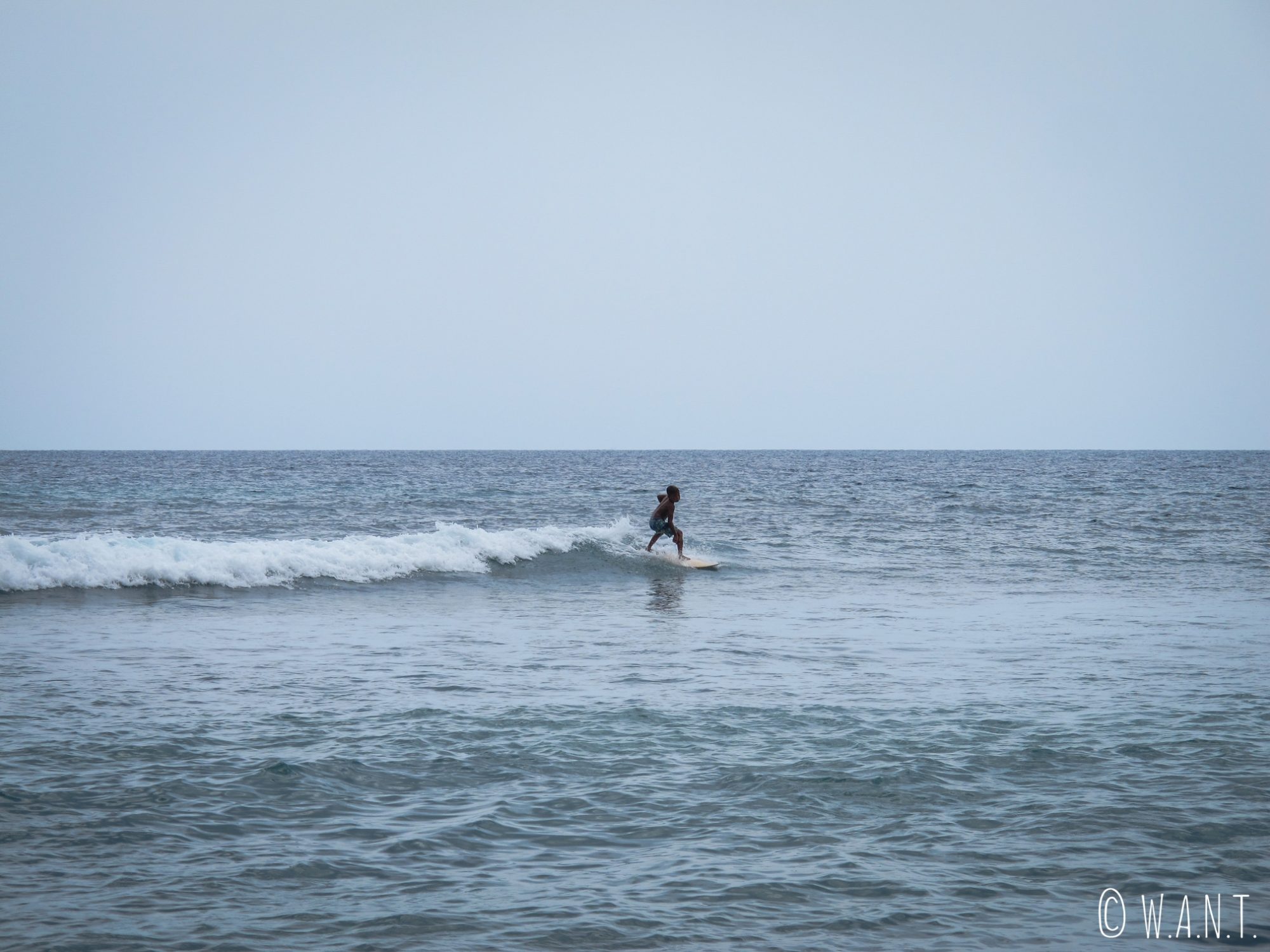 Jeune surfeur depuis la plage de Pandanan à Lombok