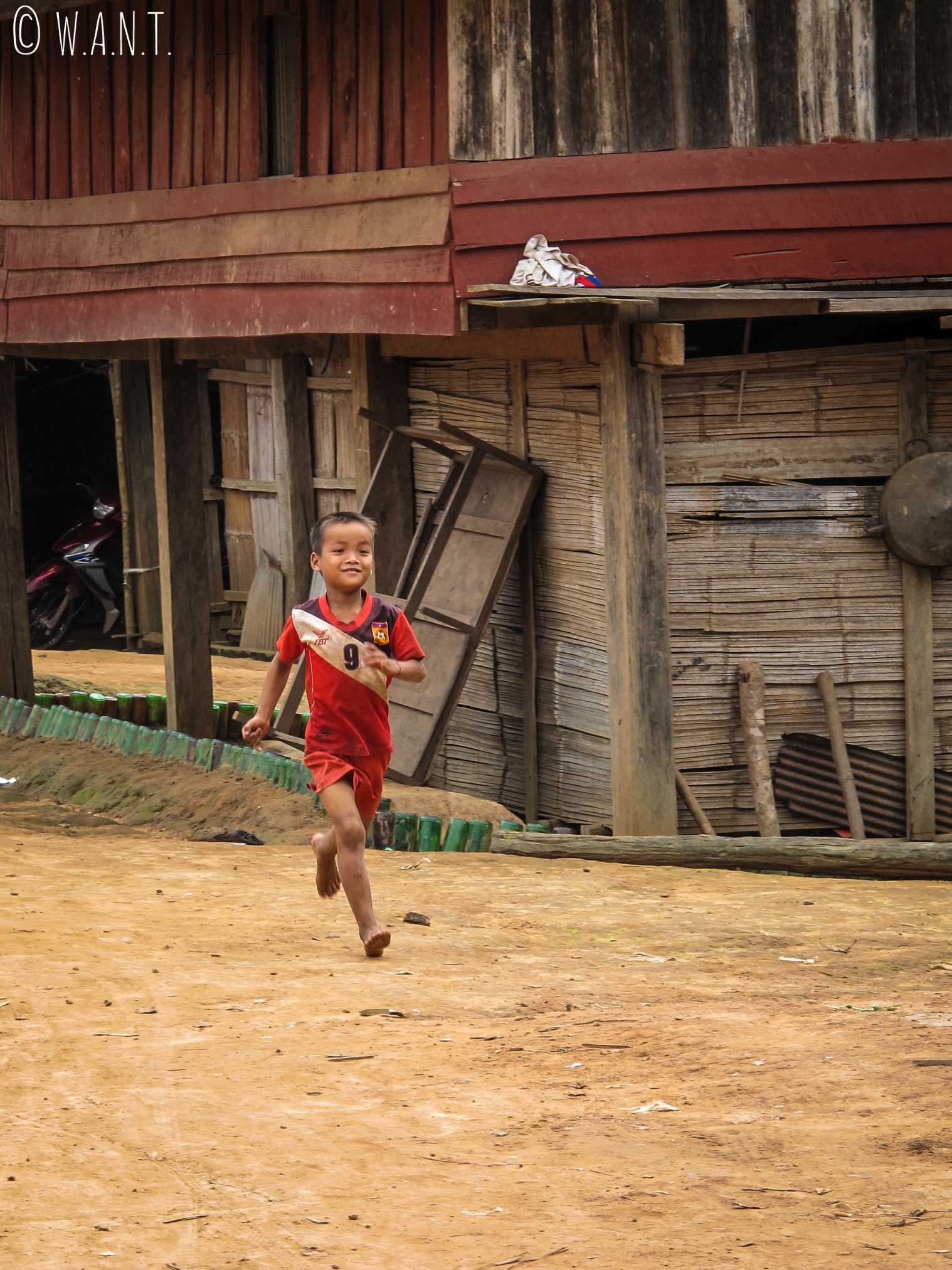 Enfant en train de courir dans un village près de Luang Namtha au Laos