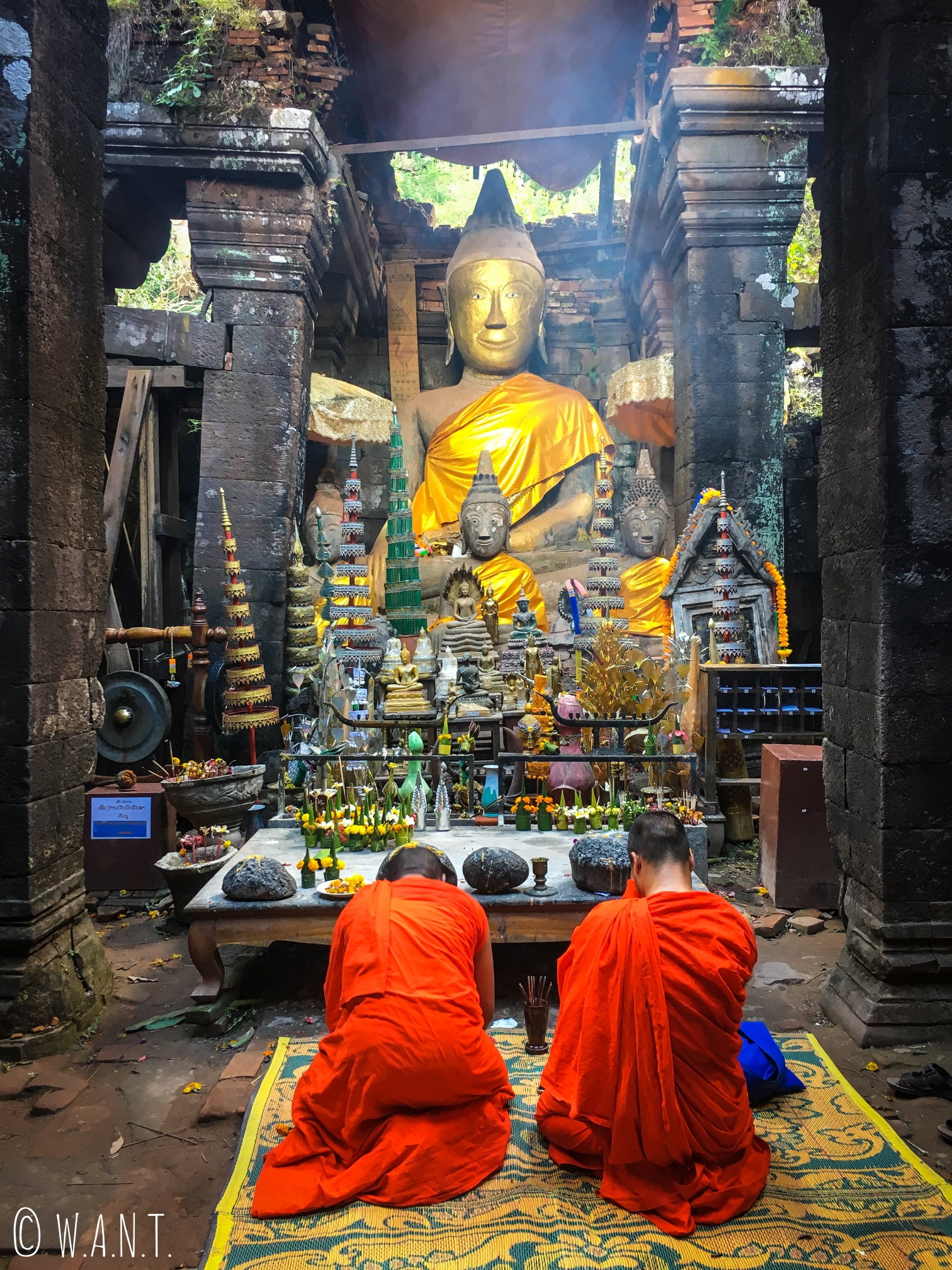 Moines se recueillant devant une statue de Bouddha sur le sanctuaire de Vat Phou