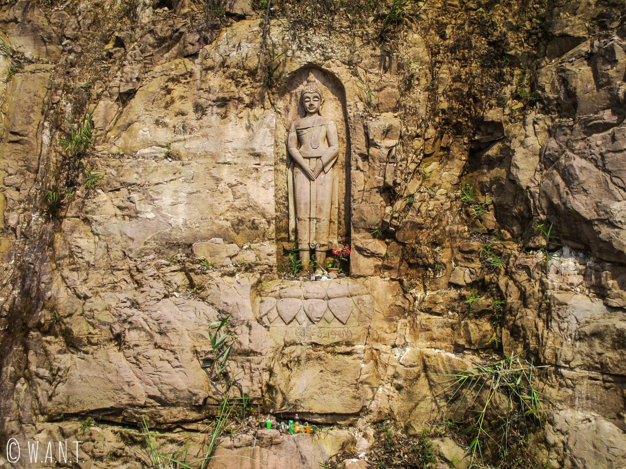Statue de Bouddha gravée dans la roche sur le bord de la route de la boucle de Thakhek