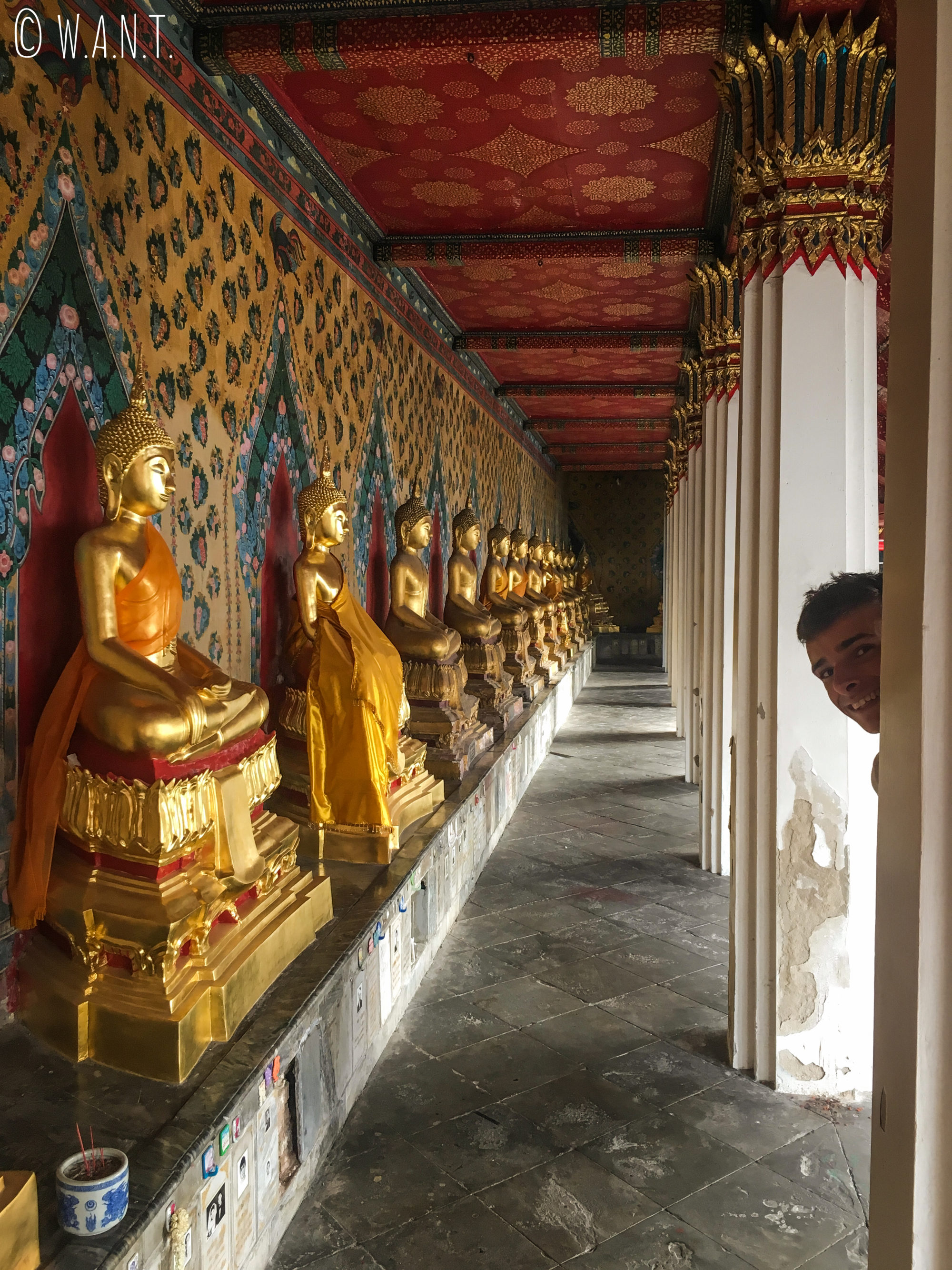 Paul se cache entre les statues de Bouddha au temple jouxtant le Wat Arun de Bangkok